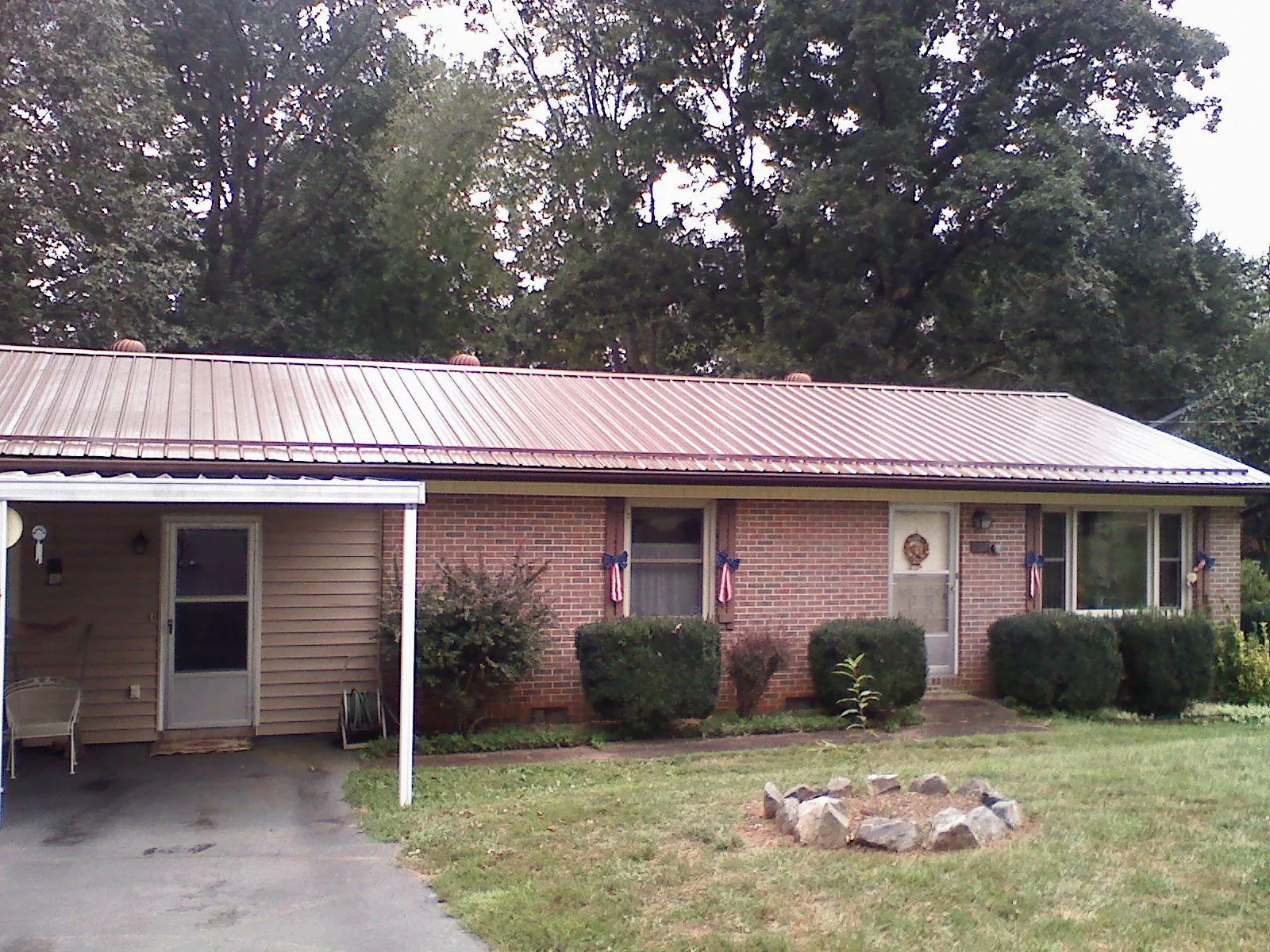 Bronze metal roof and carport on a brick ranch home — Roof Repair work by our crew in Dixon